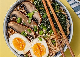 bowl of noodles with boiled egg and mushrooms