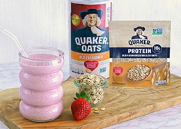 glass of a pink smoothie with strawberries and oats