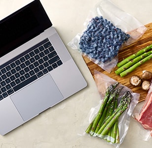 laptop next to blueberries and asparagus