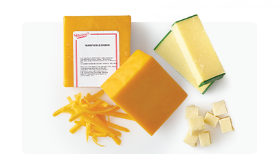 Assorted Cheddar cheeses on a white surface