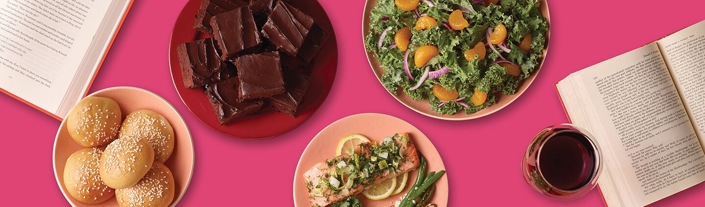 assorted potluck dishes including salmon, kale and mandarin orange salad, brownies, red wine and chapter books