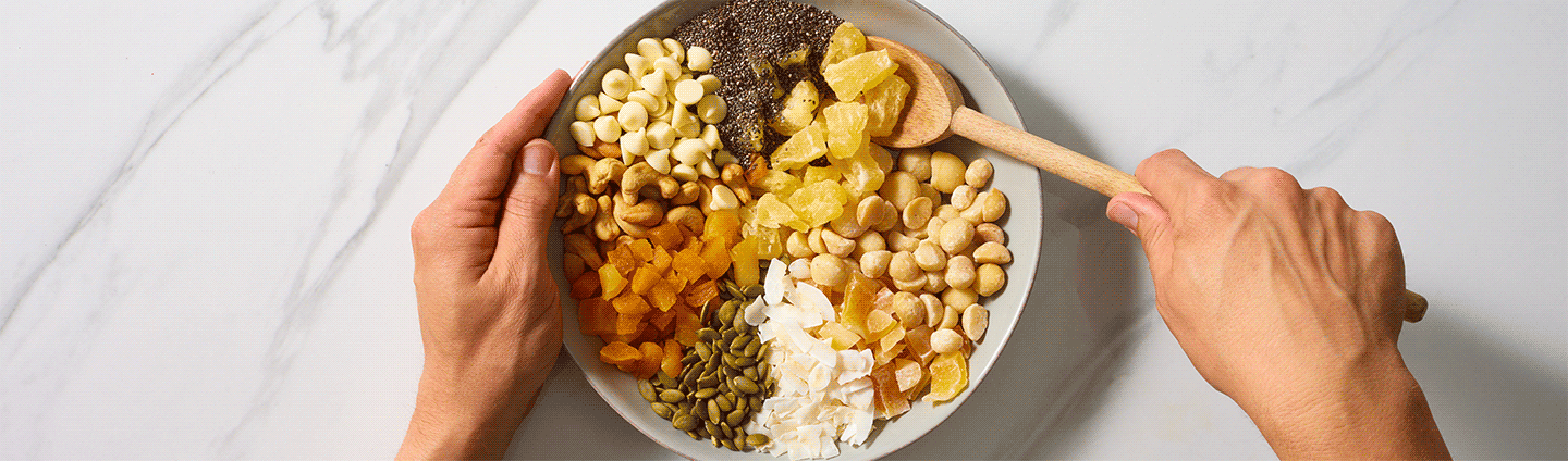 someone mixing granola ingredients