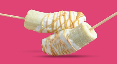 Bananas dipped with yogurt and drizzled with peanut butter