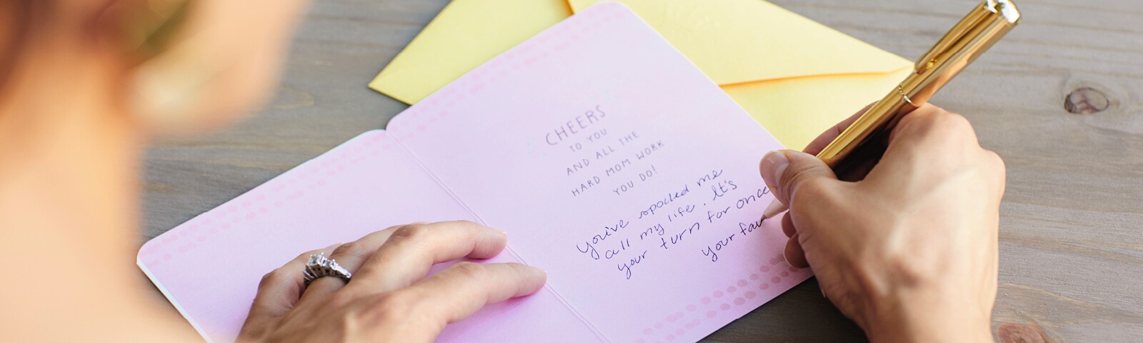 A woman creating a to-do list on pink paper A woman creating a to-do list on pink paper