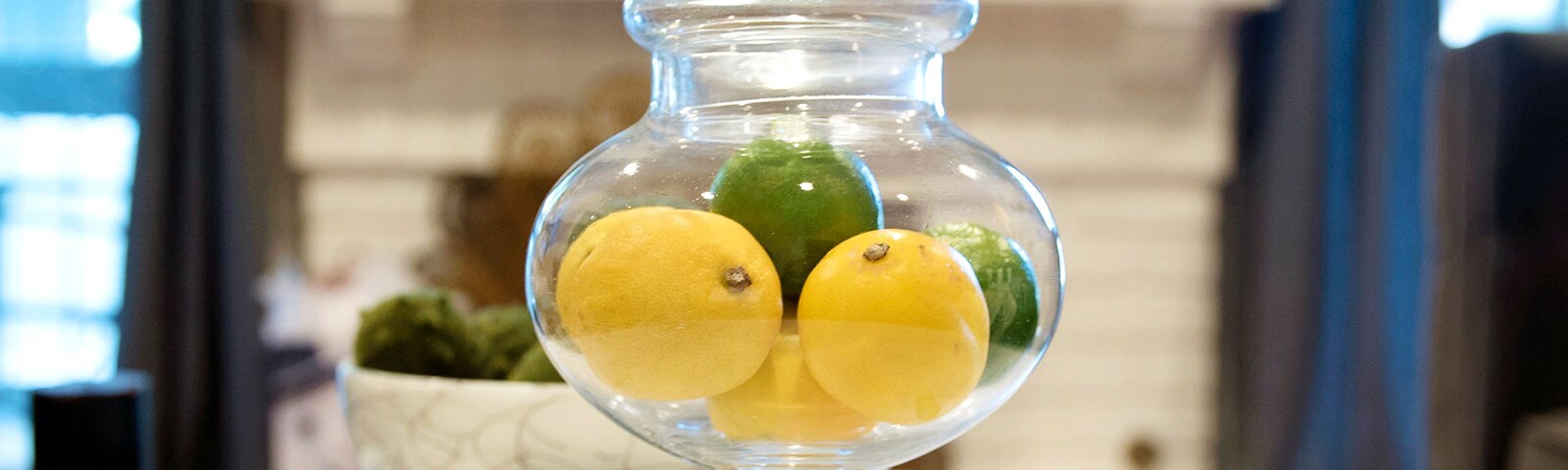 Lemon and Limes in a glass jar on a table Lemon and Limes in a glass jar on a table