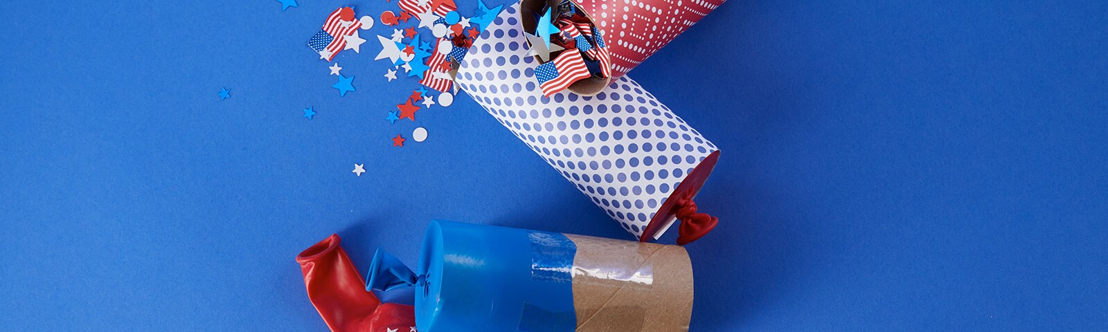 Toilet paper tubes decorated as confetti poppers with patterned paper, stickers and glitter on a blue background Toilet paper tubes decorated as confetti poppers with patterned paper, stickers and glitter on a blue background