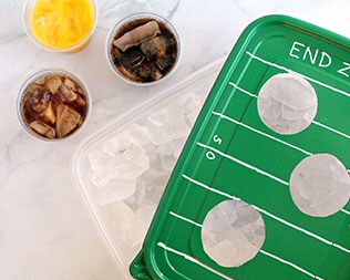 Finished tray: football-themed green rectangle container lid over ice that's ready to serve drinks Finished tray: football-themed green rectangle container lid over ice that's ready to serve drinks