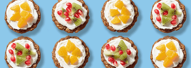 Assorted baked oatmeal cups topped with yogurt, oranges, kiwi and pomegranates